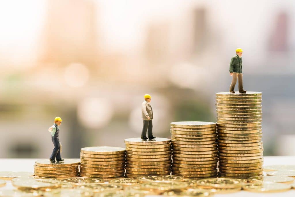 Kolikkopinojen päälle asetetut pienoistyömaakoneet ja -työntekijät symboloivat liiketoiminnan kasvua ja investointeja. Mitä korkeampi pino, sitä korkeammalla hahmo seisoo, kuvaten taloudellista kehitystä ja yritysrahoituksen mahdollisuuksia. Kuva viittaa yrityslainaan, laskurahoitukseen ja leasinglimiittiin, jotka auttavat yrityksiä kasvattamaan toimintaansa.